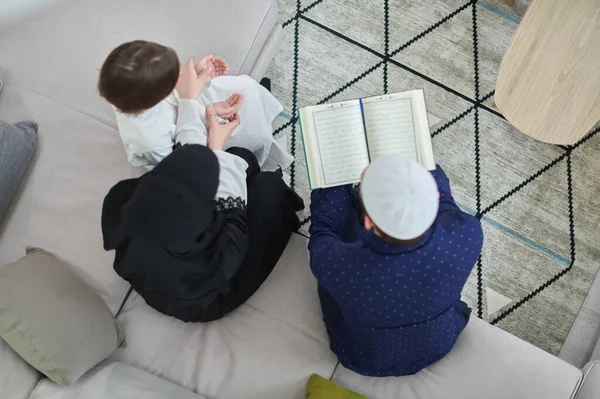 ラマダーン中のクルアーンを読む若いイスラム教徒の家族のトップビュー — ストック写真