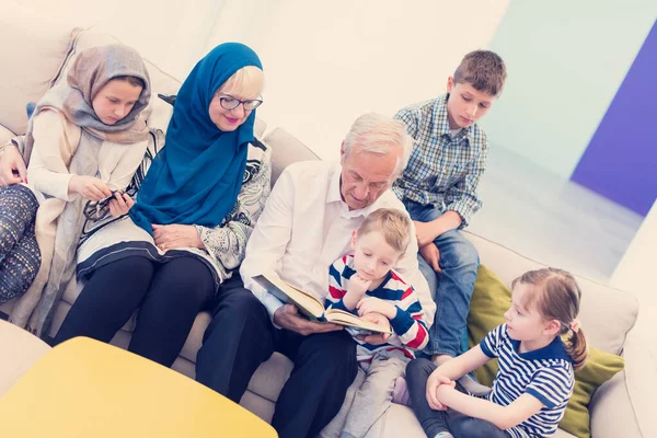 現代のイスラム教徒の祖父母と孫がコーランを読む — ストック写真