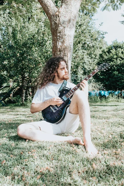Atraktivní Muž Dlouhými Vlasy Hrát Akustickou Kytaru Venku Hippie Relaxovat — Stock fotografie