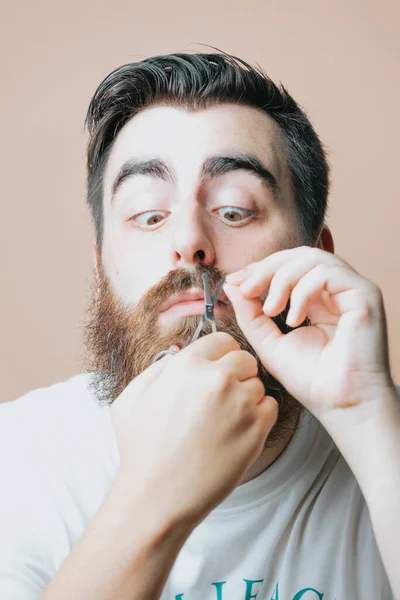 Young bearded man comb his beard