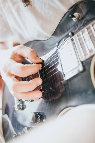 Close up of a pair of hands playing a guitar outdoors. Sunny day and practicing an instrument concept. Copy space music life on tour and nature.