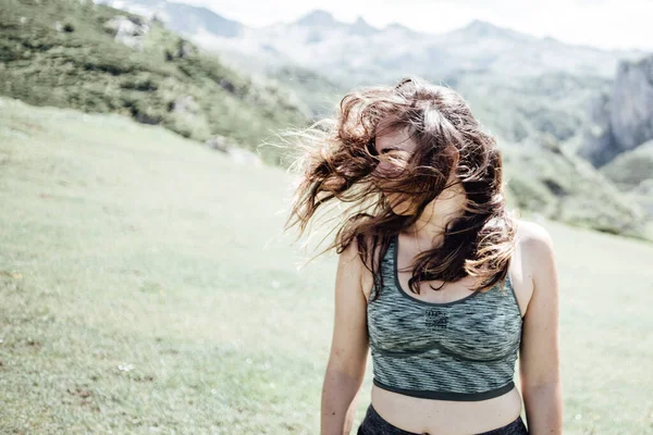Spor Kıyafetleriyle Dağların Tepesinde Saçlarını Sallayan Genç Bir Kadının Kavramsal — Stok fotoğraf
