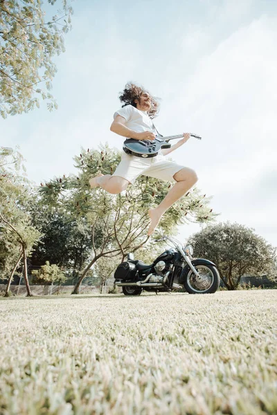 Attractive Man Long Hair Playing Acoustic Guitar While Jumping Outdoors — Fotografia de Stock
