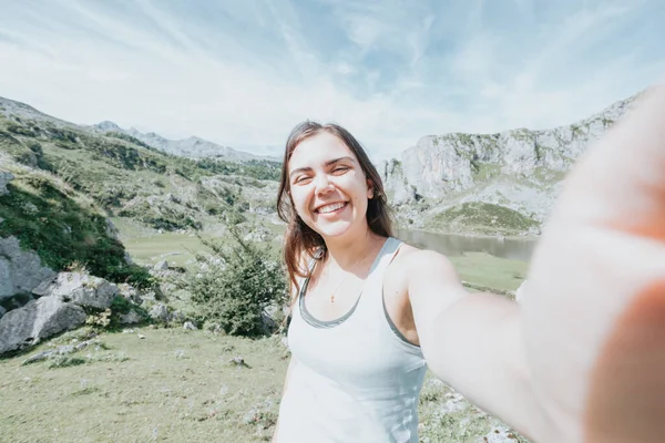 Jovem Mulher Tirando Uma Selfie Topo Das Montanhas Enquanto Sorri — Fotografia de Stock