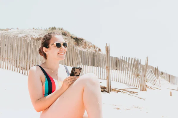 Young Woman Smiles While Chatting Phone Wearing Colorful Swimsuit Beach — Stockfoto