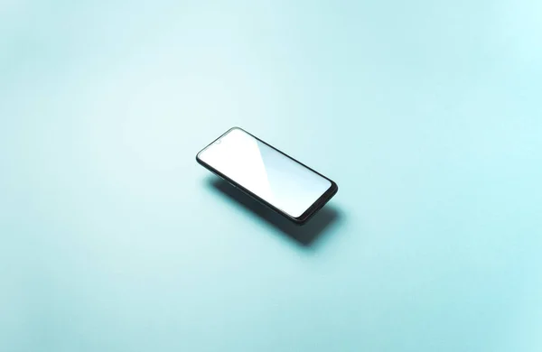 Top view of mobile phone floating blank scree template on pastel pastel blue background with copy space, minimal design, shapes