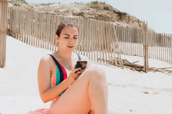 Young Woman Surprised While Chatting Phone Wearing Colorful Swimsuit Beach — Fotografia de Stock