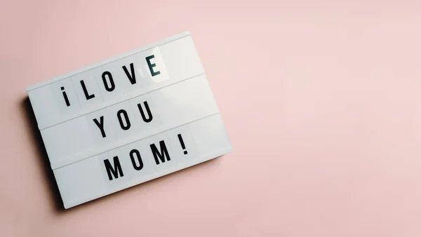 Mom day sign over a pastel pink background says love you mom, love concept, minimal, copy space, style design