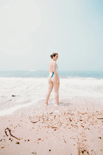 一位年轻女子在海滩上的画像 她享受着温暖的热带海水 五彩缤纷的泳衣 明亮的大海 — 图库照片