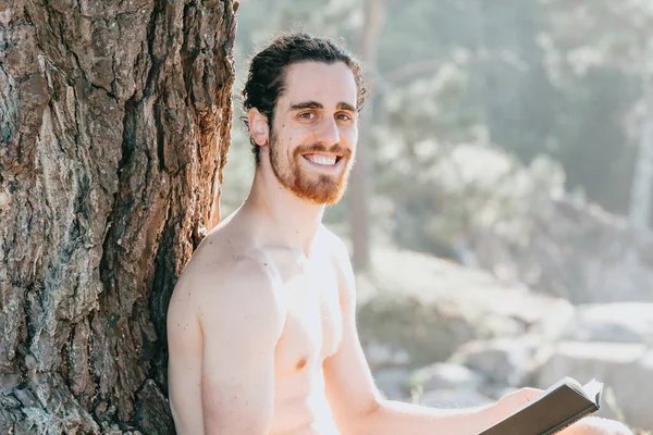 Close Man Beard Holding Book Smiling Camera Shirtless Next Tree — Stok fotoğraf