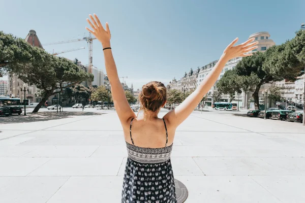 stock image Back of a woman celebrating in the main plaza of porto, Oporto, during a super sunny day, relax and holiday concept, hot day, summer, dress