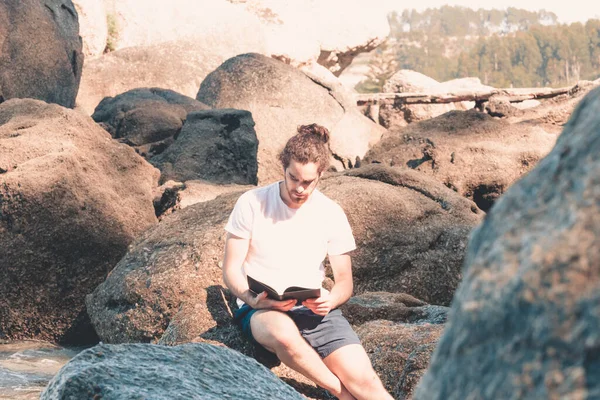 Young Hippie Man White Shirt Reading Book Rock Beach Summer — Stock Photo, Image