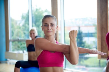 Yoga dersinde toplarla egzersiz yapan bir grup insan.