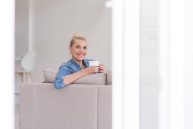 Genç bayan bir fincan kahvenin keyfini çıkarıyor.