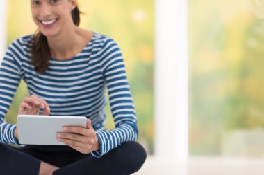 tablet bilgisayar yere kullanan genç kadın