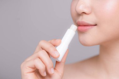 Woman With Beauty Face Applying Lip Balm