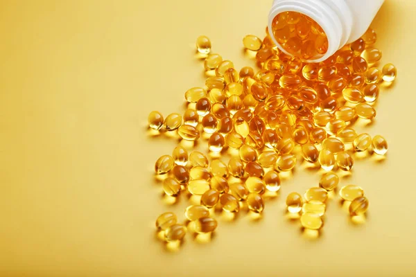 Golden Omega Fish Oil Capsules Poured Out Jar Yellow Background — Stock Photo, Image
