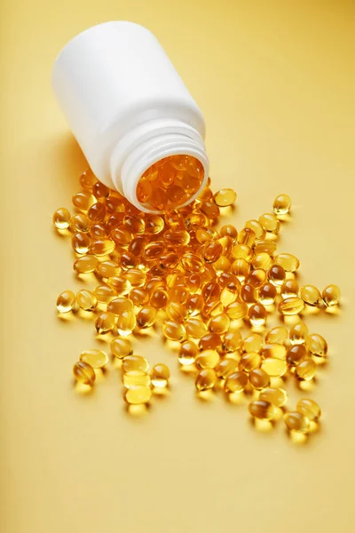 Golden Omega Fish Oil Capsules Poured Out Jar Yellow Background — Stock Photo, Image