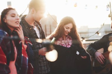 Müzik çalıyorum. Bu bir çatı partisi. Bir grup arkadaşın güneşli sonbahar gününde tatili var.