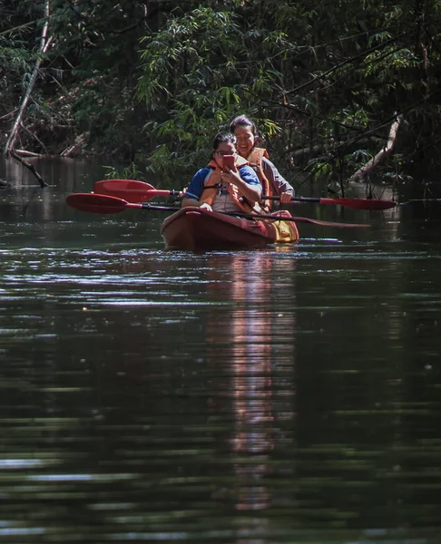 二人の若いです冒険的な人々を楽しみます一緒に赤カヤックで小川に森 — ストック写真