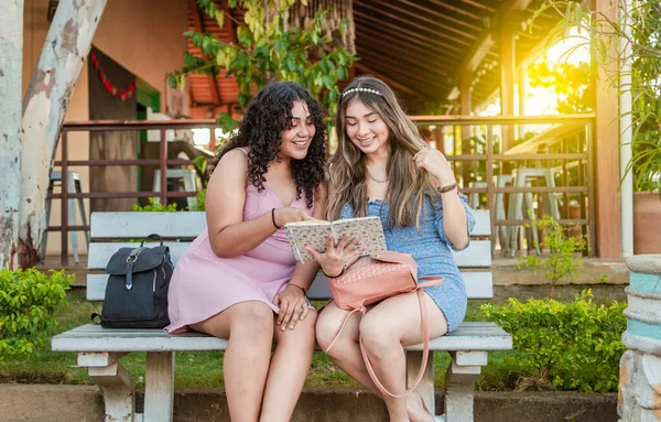 二人の可愛い女の子がベンチで本を読んでる二人の可愛い女性がベンチで読書してる女の子が座ってる — ストック写真