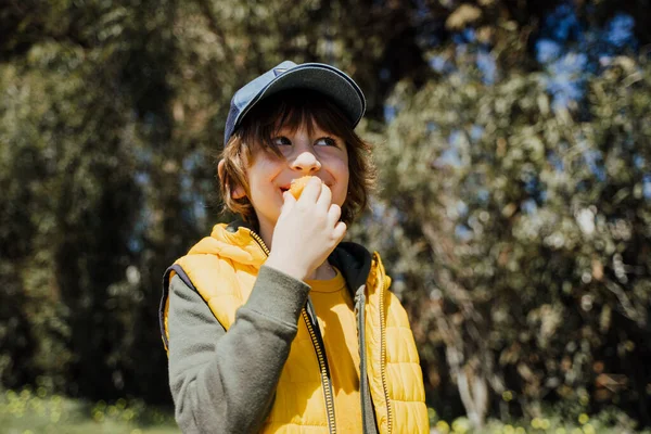 Smiling Cheerful Child Kid Yellow Vest Green Hoodie Eats Crisp — Stock Photo, Image