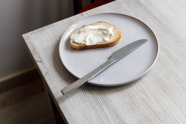 Beyaz Bir Seramik Tabağa Serpiştirilmiş Krem Peynirli Bir Parça Ekmek — Stok fotoğraf