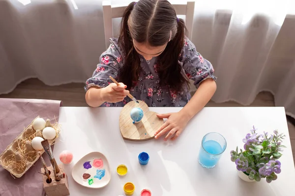 Little Girl Sits White Table Window Paints Eggs Brush — Stock Photo, Image