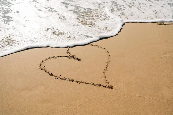 Αγόρι Κίτρινες Λαστιχένιες Μπότες Που Ζωγραφίζει Σχήμα Καρδιάς Στην Άμμο — Φωτογραφία Αρχείου