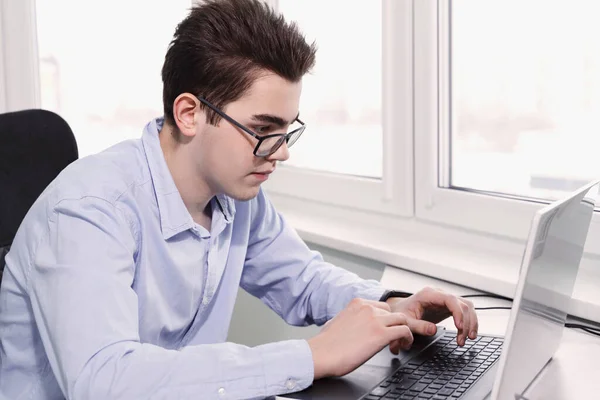 Junger Mitarbeiter Schaut Auf Laptop Bildschirm Und Tippt — Stockfoto