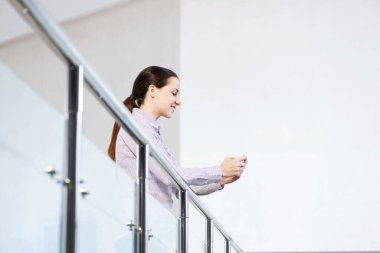 Ellerinde telefonla genç ve çekici bir kadın.