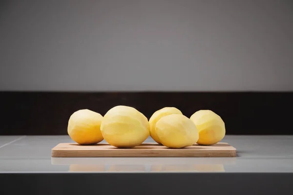 Close Several Peeled Potatoes Wooden Cutting Board White Table — Stock Photo, Image