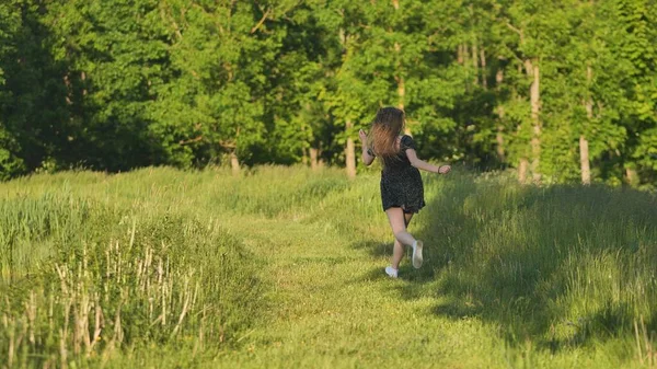 Genç Bir Kız Sıcak Bir Yaz Akşamında Çayırda Koşar — Stok fotoğraf