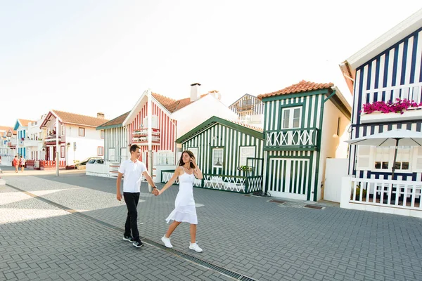 白い服を着た若いカップルは カラフルで平和な家の近くにポルトガルのアヴェイロの通りを歩き回っています ライフスタイル 楽しさ — ストック写真
