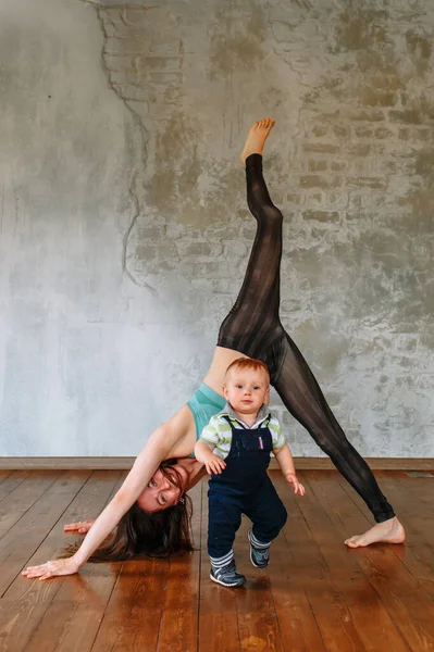 Dziewczyna Jogi Wykonuje Ćwiczenia Podczas Gdy Jej Mały Syn Biega — Zdjęcie stockowe