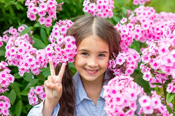 可爱的小女孩 站在郁郁葱葱的粉色凤尾花里 夏天在花园里 — 图库照片