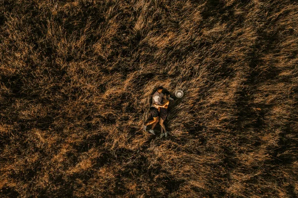 Ζευγάρι Των Ανθρώπων Βρίσκεται Ψηλό Γρασίδι Στο Ηλιοβασίλεμα Κορυφή Θέα — Φωτογραφία Αρχείου