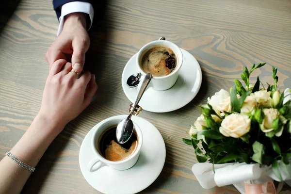 Γάμος Ζευγάρι Κρατώντας Χέρια Φλιτζάνια Του Καφέ Στο Ξύλινο Τραπέζι — Φωτογραφία Αρχείου