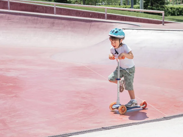 Kleiner Junge Fährt Tretroller Skatepark Spezielle Betonschalenkonstruktionen Stadtpark Skatetraining Sommer — Stockfoto