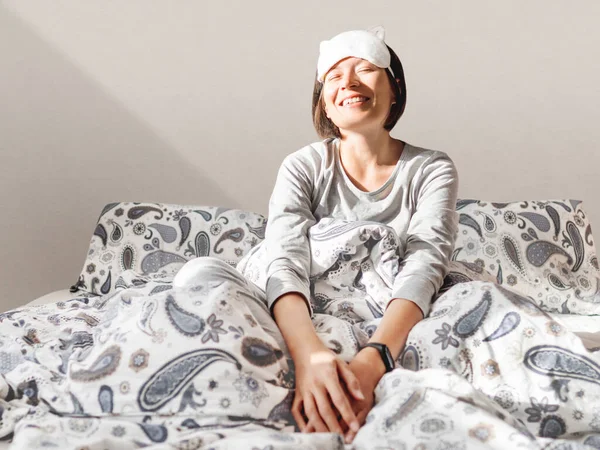 Mujer Sonriente Pijama Gris Máscara Para Dormir Acaba Despertar Sienta — Foto de Stock
