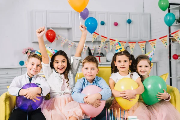 孩子们抱着气球坐在沙发上 — 图库照片