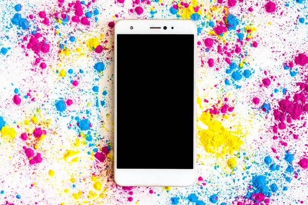 黒画面表示のスマートフォンの周りにホリ色の粉 — ストック写真