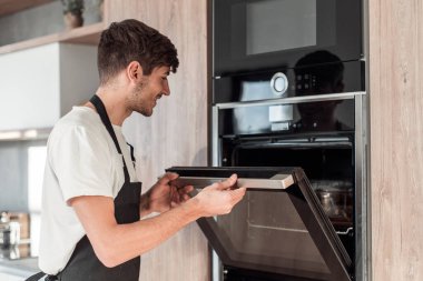 Müdür, genç bir çalışanı el sıkışmasıyla tebrik ediyor.