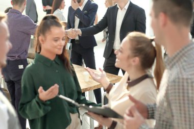 Genç çalışanlar ofiste konuşuyorlar.