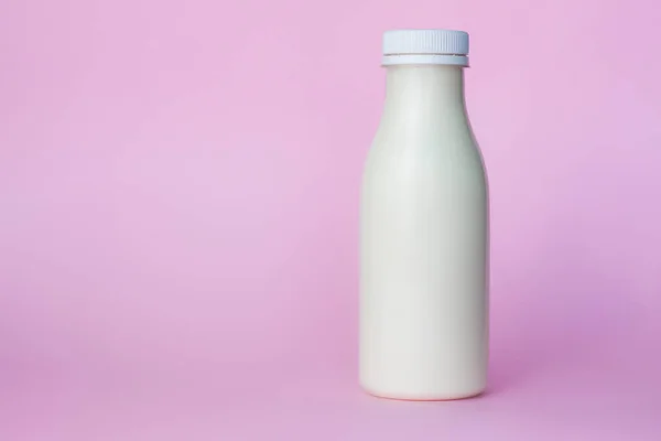 Butelka Białego Mleka Podkreślona Różowym Tle Zbliżenie — Zdjęcie stockowe