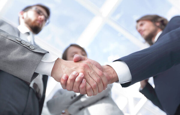 team looking at a business handshake partner.