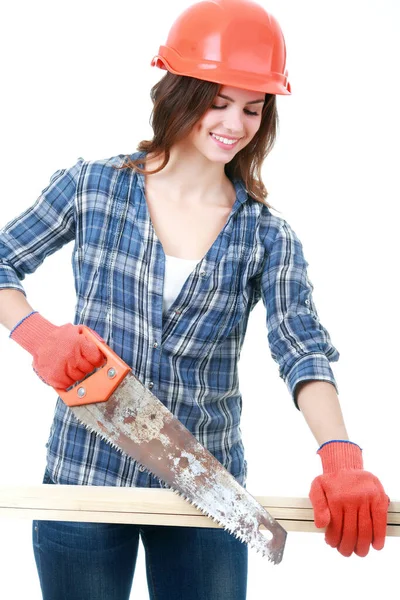 钢盔切割木板的年轻女建筑工人 — 图库照片
