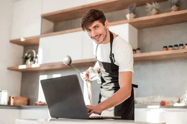 Young Man Looking Laptop Screen While Cooking Dinner — Stock Photo, Image