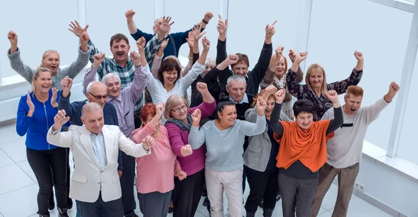 高齢の友人のグループが手を挙げて成功を祝い — ストック写真
