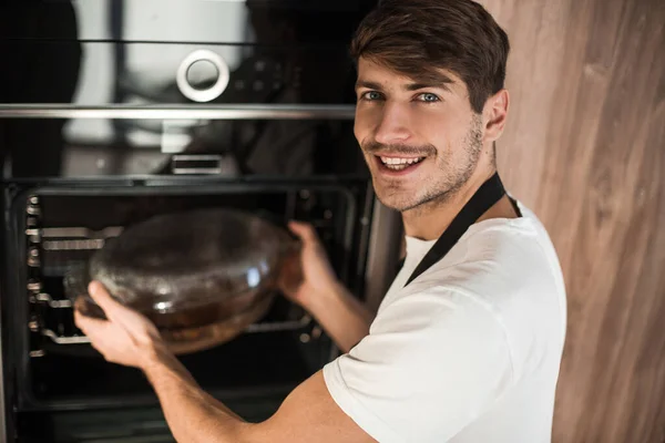 Sorrindo Jovem Aquecendo Jantar Sua Cozinha — Fotografia de Stock